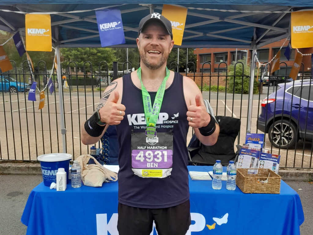 a man stands wearing a dark blue running vest