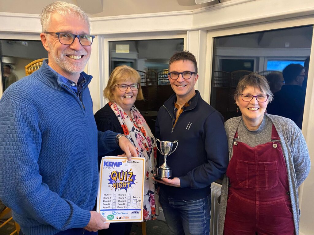 four people stood with a trophy smiling holding a certificate