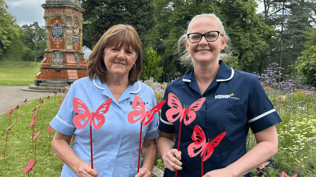 two nurses stood holding red metal butterflies