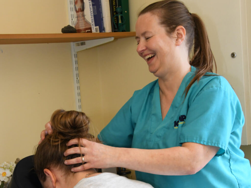 a lady in scrubs gives a reiki head massage