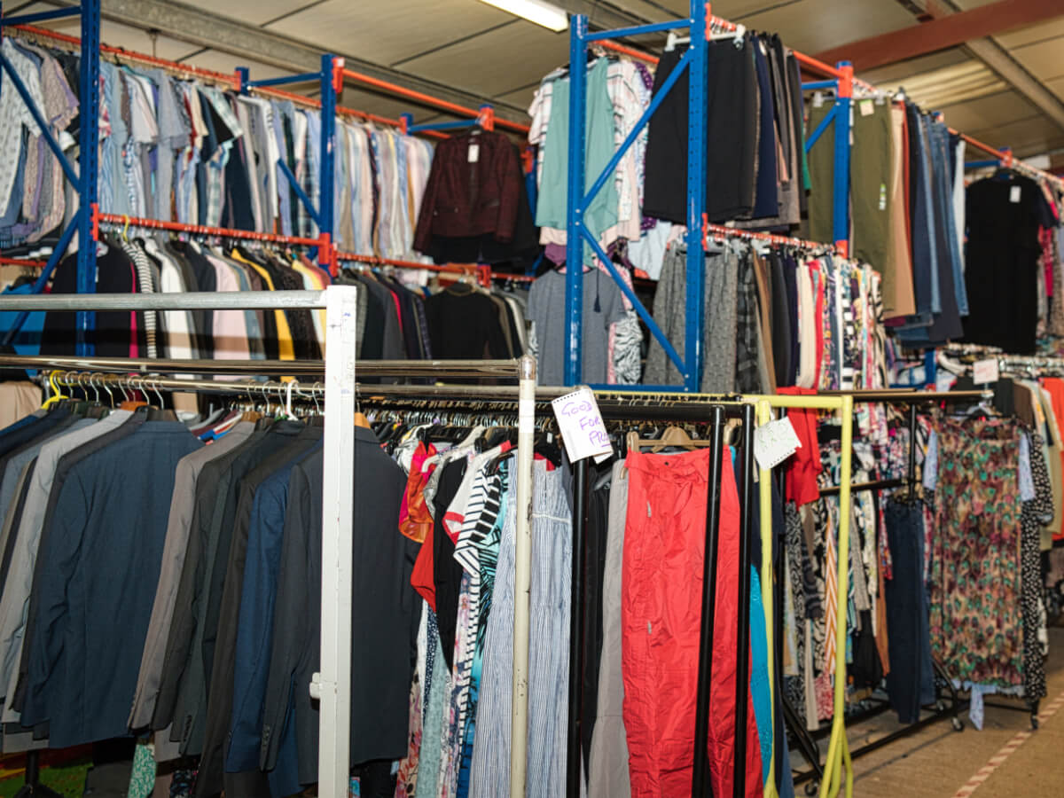 clothes on several rails in a warehouse