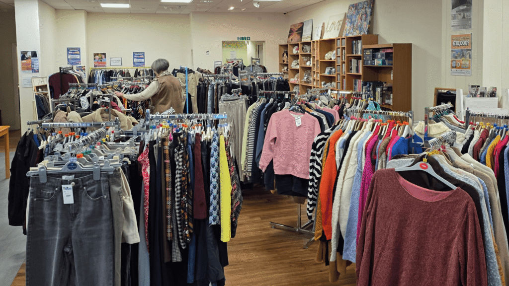 clothes rails in a shop with a lady looking at the clothing