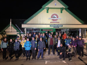 a group of people stand outside the base of mount snowdon