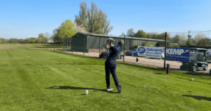 a person stands ready to tee off in golf