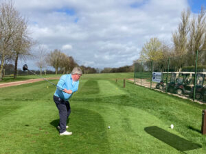 a person stands on a golf course teeing off