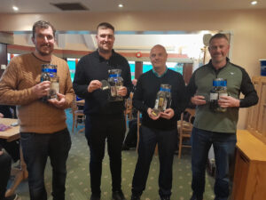 four people stand holding prizes