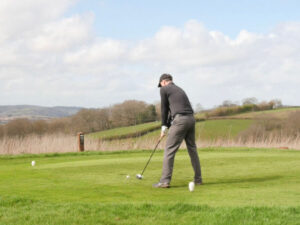 a person stands on a golf course getting ready to take a swing at the golf ball