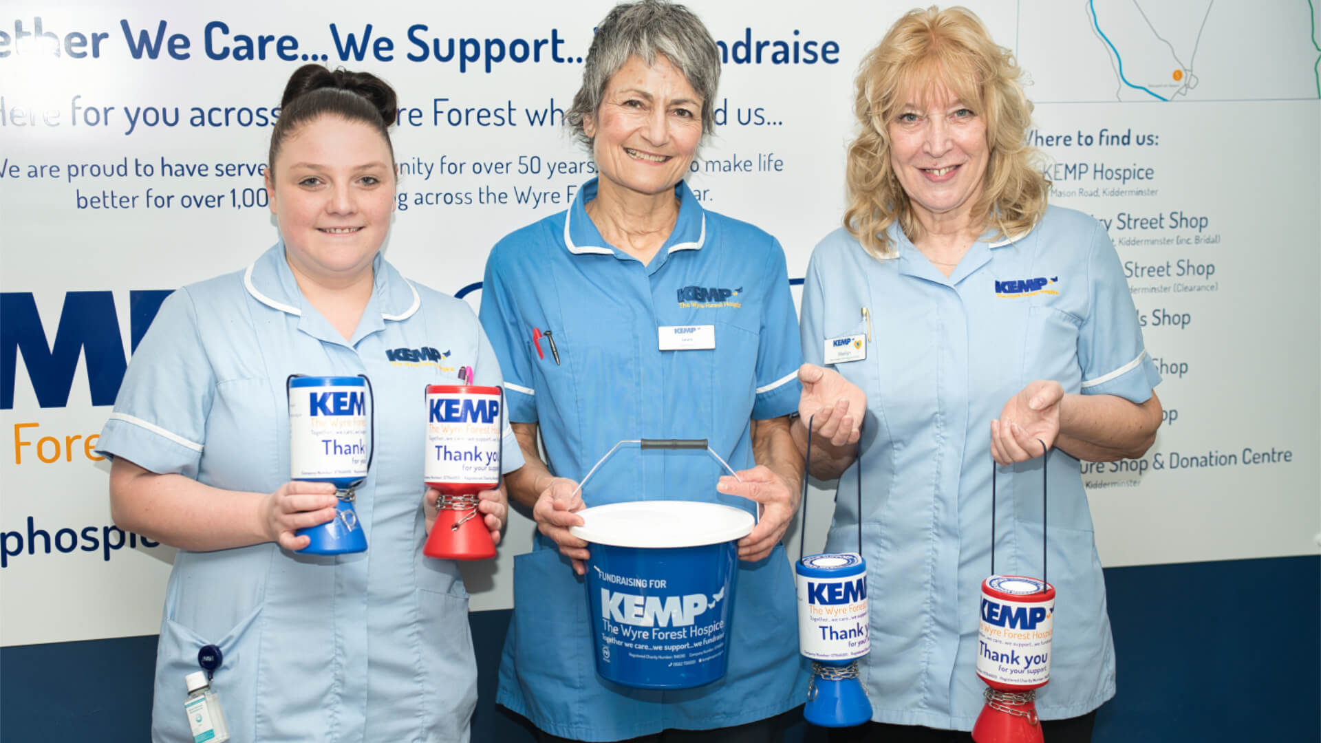 three nurses stand wearing scrubs holding collection buckets