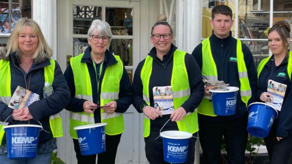 a group of people wear high vi vests and hold collection buckets