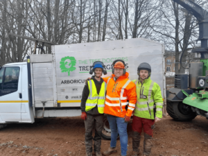 three people stand by a work van