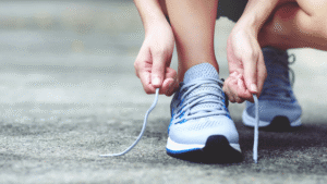 a close up of someone lacing up a running shoe as if to start a road run