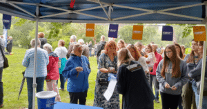 a group of people stand under a marquee