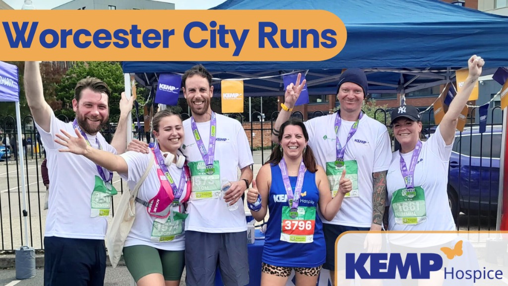 a group of people stand cheering with hands in the air with running medals round their necks.