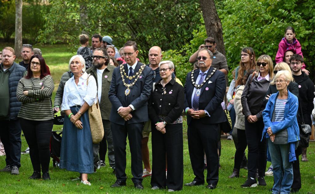 a group of people stand together in a wooded area