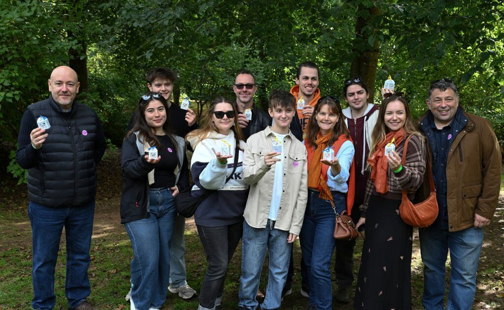 a group of people stand in a wooded area