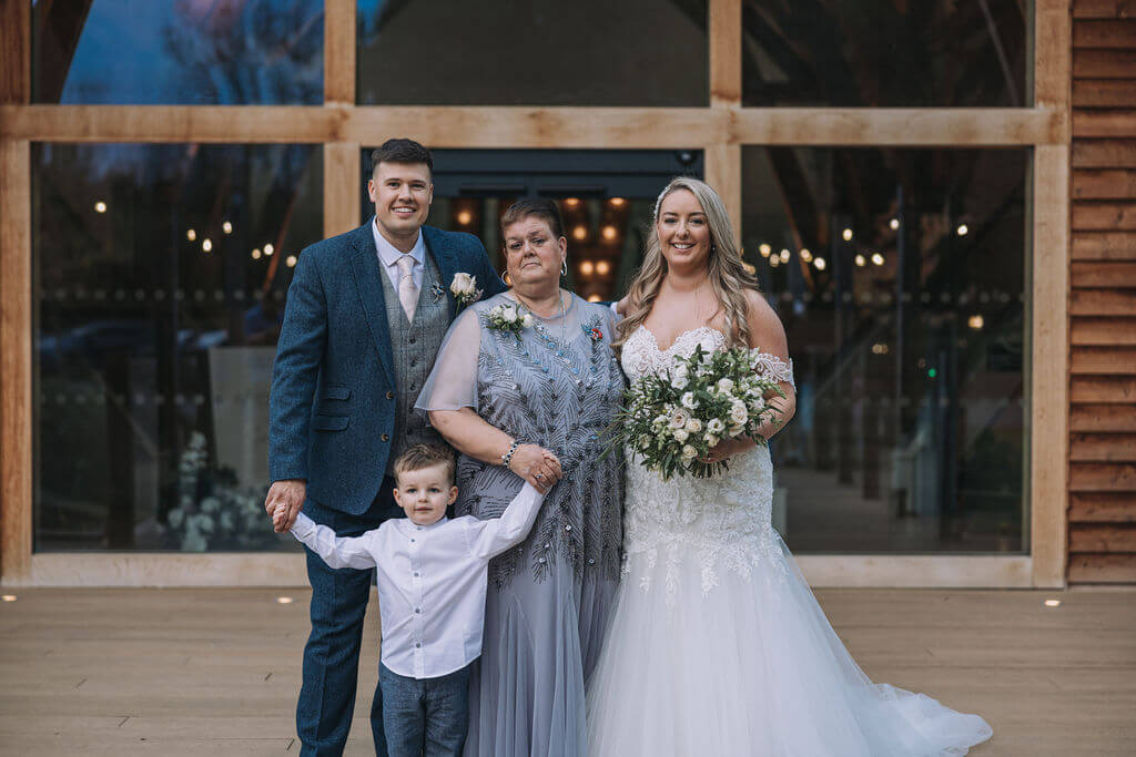 A wedding photo of a groom, bride and family