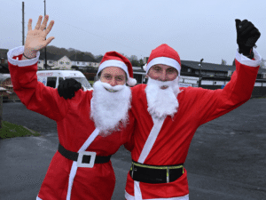 two people stood together wearing santa suits at the kemp santa fun run