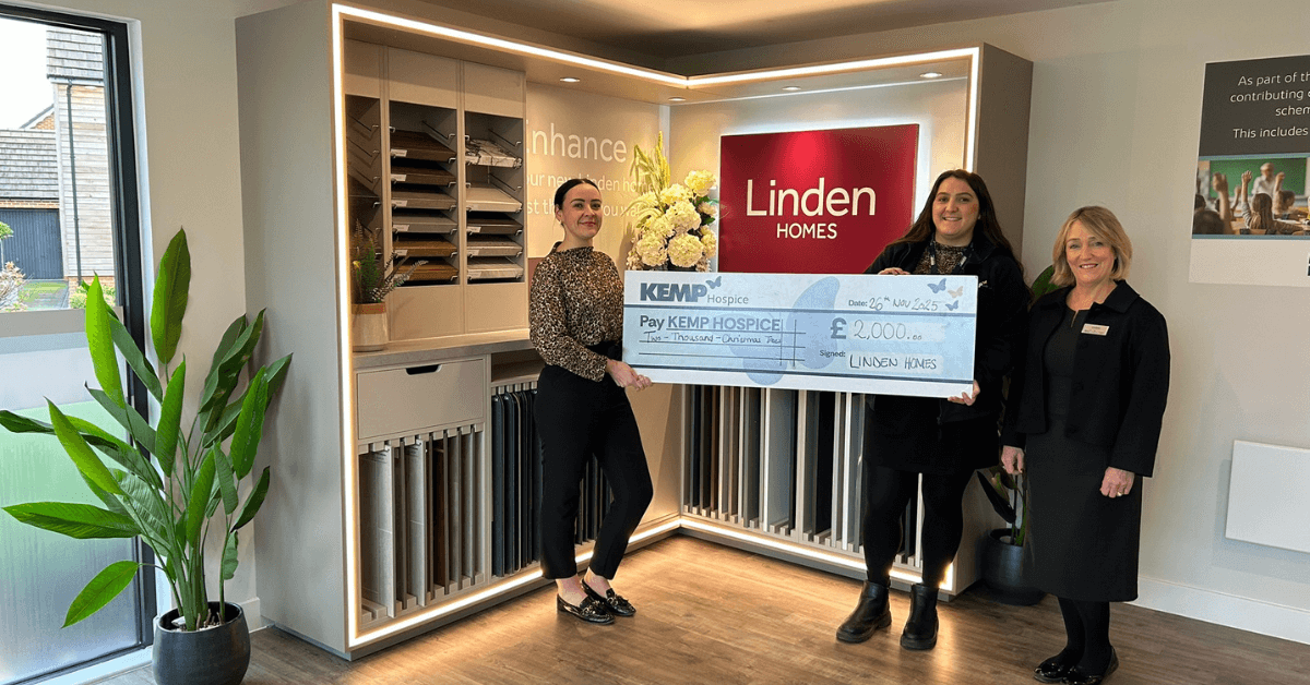 three ladies stand in a room with tile samples and a linden homes sign in the background. They are holding a large cheque made out to kemp hospice.
