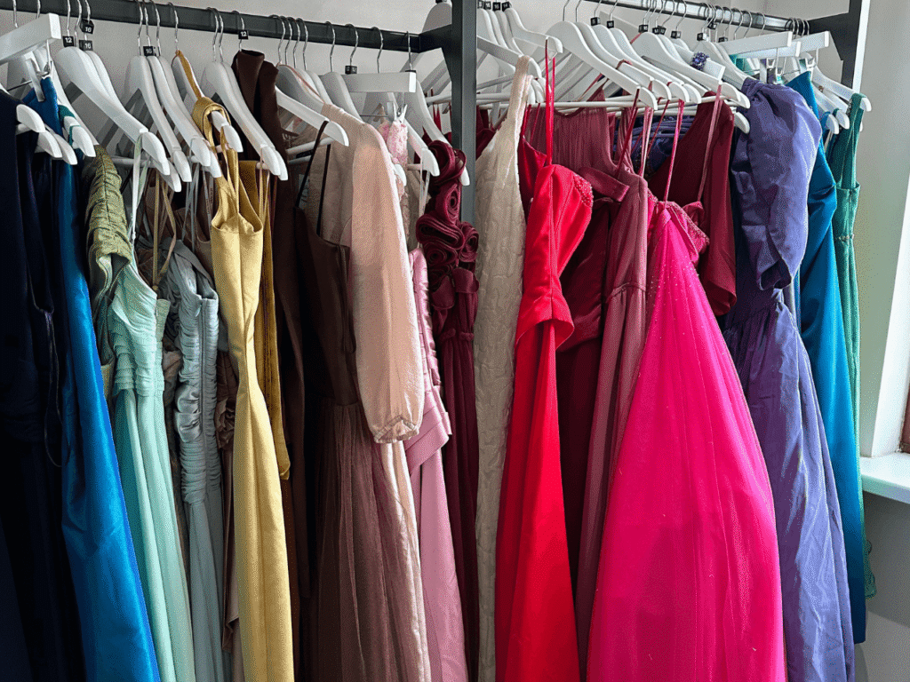 A selection of colourful dresses hang on a shops clothes rail
