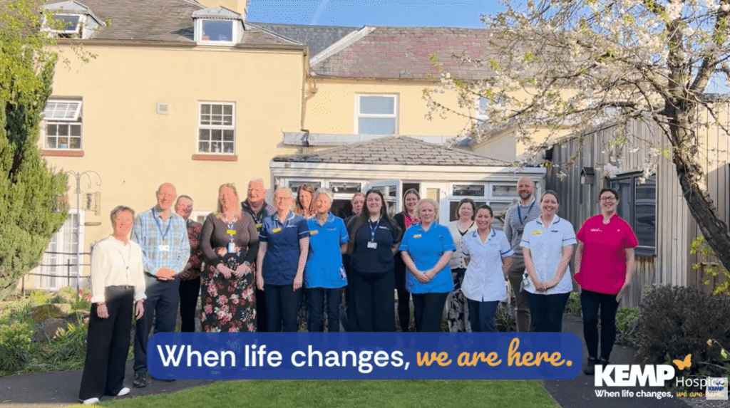 a greopu of people stand in front of the kemp hospice building
