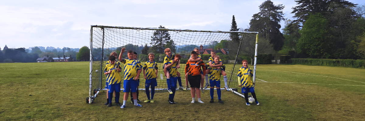 a groups of young people stand in a goal wearing football kits