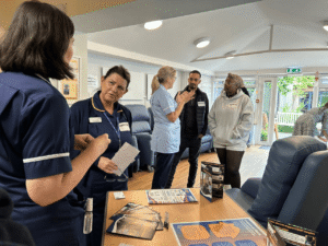 a group of people stand talking including people wearing nursing uniforms