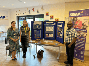 a group of people stand next to a table with display boards and banners