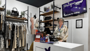 a lady stands behind a shop till