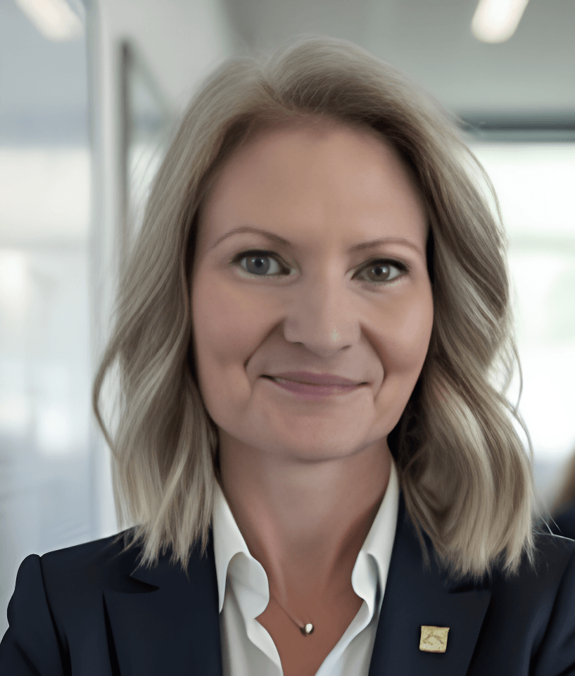 head and shoulders of a lady with wavy blonde hair wearing a suit jacket and white shirt