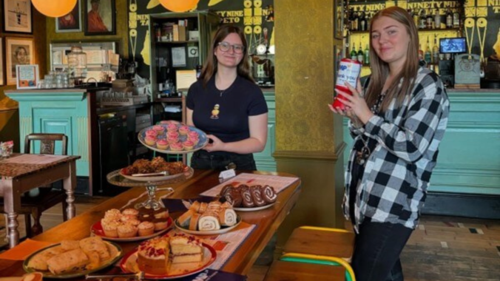 two women holding a collection tin and cakes