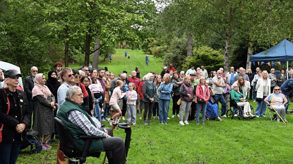 A group of people stand in a grassy area