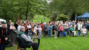 A group of people stand in a grassy area