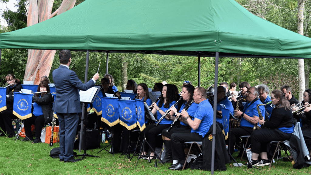 A concert band playing under a green gazebo