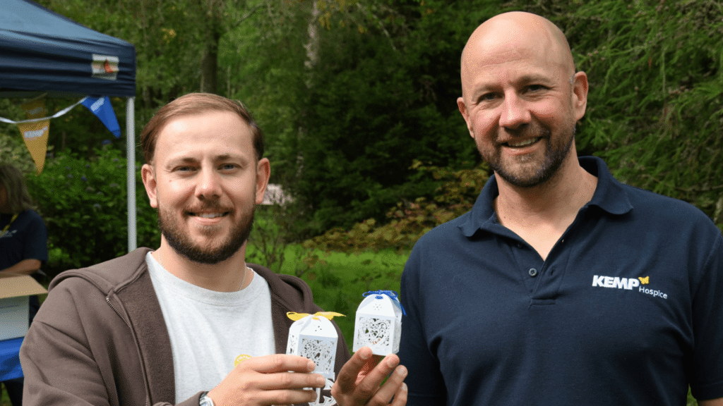 two people stand holding decorative white boxes with butterflies inside