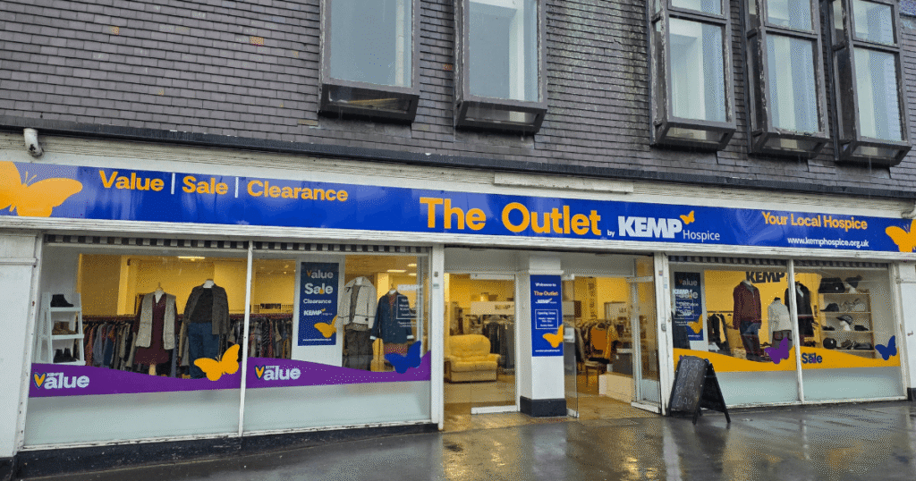 External shop facade with clothing items in the windows on display
