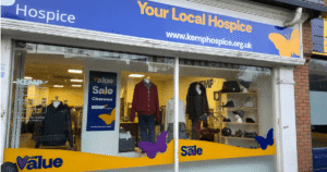 External shop facade with clothing items in the windows on display