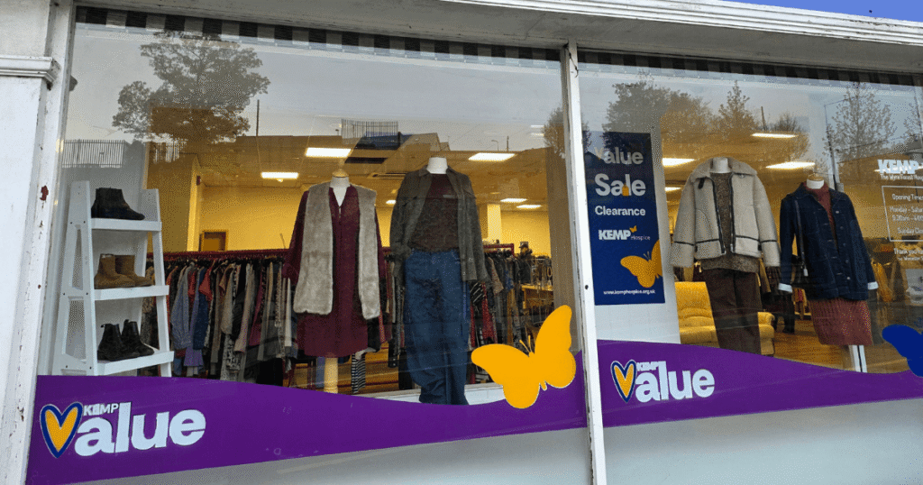 External shop facade with clothing items in the windows on display