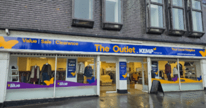 External shop facade with clothing items in the windows on display