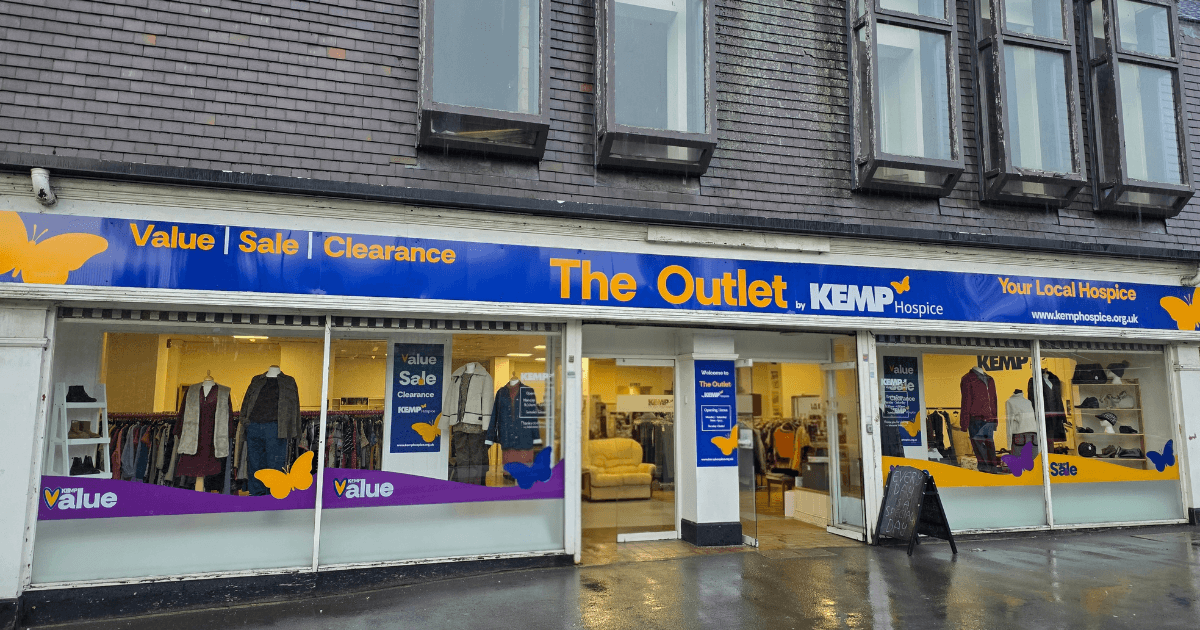 External shop facade with clothing items in the windows on display